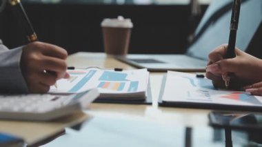 Çalışma ekibi masadaki ve dizüstü bilgisayardaki belgelerle çalışıyor