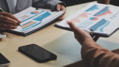 Genç Asyalı iş kadını, iş dünyasının mali verilerini analiz etmek için tablet kullanıyor..