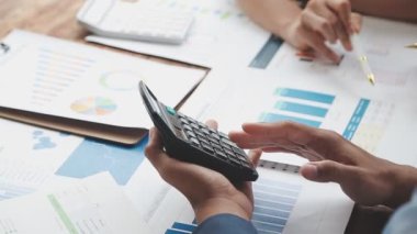 Hesap makinesi ve dizüstü bilgisayarla çalışan iş adamları