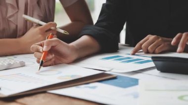 Genç Asyalılardan oluşan bir ekip ofiste proje üzerinde çalışıyor.