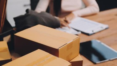 Ofisteki masanın üstünde dizüstü bilgisayarla kutuları toplayan kadın. çevrimiçi iş kavramı