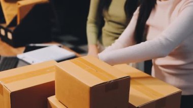 Siyah takım elbiseli genç bir kadın ve dükkanında bir paket..