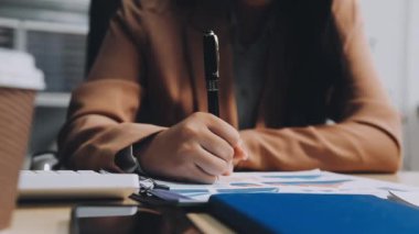 İş kadını ofiste çalışıyor, notlar yazıyor.