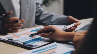 Raporu analiz etmek için hesap makinesi ve kalem kullanan işadamlarının kapatılması.