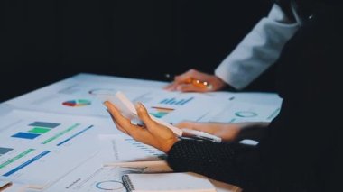 İş kadını, ofis masasında grafik ve çizelge ile çalışıyor.