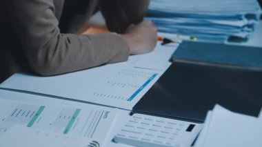 Ofis masasında dizüstü bilgisayar ve belgelerle çalışan iş adamı