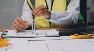 Ofiste taslak ve planla çalışan mühendis veya mimar