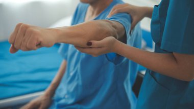 Egzersiz halter tedavi hakkında kol ve omuz sporcu ile erkek hastanın fizik tedavi kavramı veren fizyoterapist adam