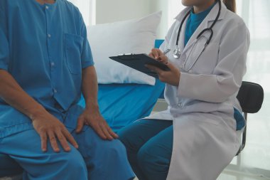 Genç bayan doktor ve hemşireler hastanede konsültasyon yapan yaşlı ve mutlu erkek hastalarla konuşmaya yardım ediyorlar. Değer veren, cesaretlendiren ve olgun erkekleri rahatlatan. sağlık hizmeti kavramı