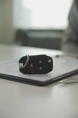 Genç bir adam araba satıcısından bir anahtar alır. Atölye, kredi kartı, sigorta, satış, araba satın alma ve finans konseptinde bir arabanın kirası veya satışı için anlaşma yaptıktan sonra.