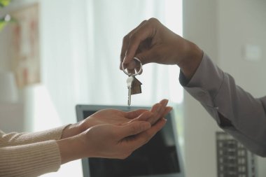 Emlakçı emlakçı ev modelini işaret eden bir kalem kullanıyor ve iş sözleşmesini, kirayı, satın almayı, ipoteği, krediyi veya ev sigortasını açıklıyor
