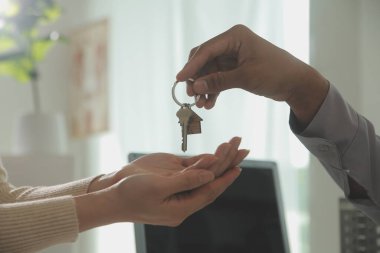 Emlakçı emlakçı ev modelini işaret eden bir kalem kullanıyor ve iş sözleşmesini, kirayı, satın almayı, ipoteği, krediyi veya ev sigortasını açıklıyor