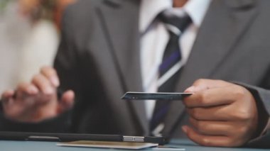 Kredi kartı tutan ve ofiste dizüstü bilgisayar kullanan işadamı, alışveriş ve internet konsepti, orijinal fotoset