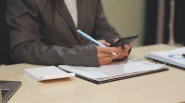 İşadamı masanın üzerinde kalem ve tablet kullanıyor.