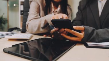 İş ekibi modern bir ofiste tartışıyor ve çalışıyor.