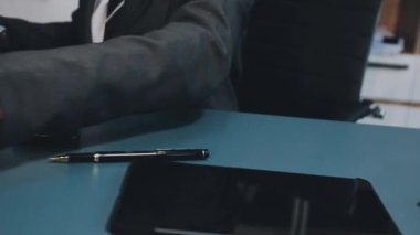 Ofiste çalışan genç bir iş adamı. Tablet kullanarak işadamını kapat