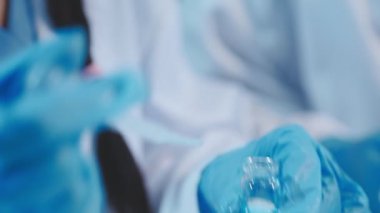 Laboratuvarda bir sıvıyla test tüpleri tutan bilim adamının yakın çekimi..