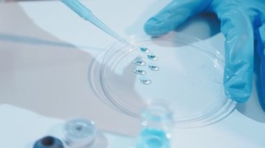 Laboratuvarda mavi sıvıyla çalışan bilim adamı