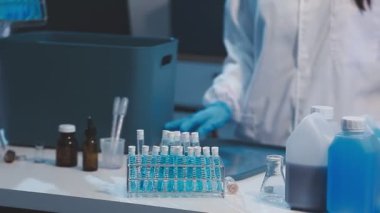 Test tüplü mavi üniformalı laboratuvar asistanı.