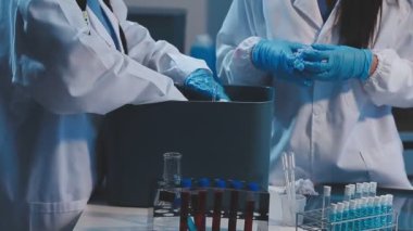 Laboratuvarda test tüpleri tutan bilim adamının yakın çekimi..