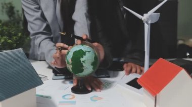 Beyaz gömlekli genç bir iş adamı ve yeşil arka planda küre ve siyah bir takım elbise.