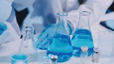 Test tüpleriyle mavi üniformalı laboratuvar asistanını kapatın.