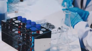 Laboratuvar asistanı kimyasallar için test yapıyor.