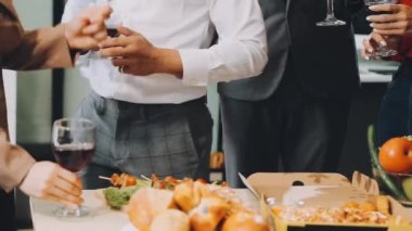 Genç iş adamları restoranda şarap içiyor, yemek yiyor, parti yapıyor, kutlama yapıyorlar.