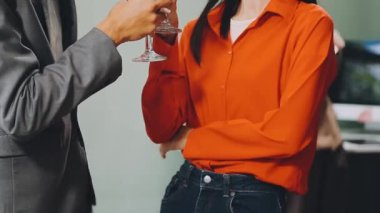 Kırmızı tişörtlü adam ve kadın ellerinde şampanya şişesi