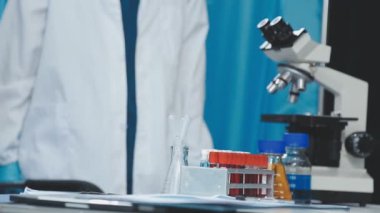 Laboratuvarda mikroskopla çalışan koruyucu eldivenli bilim adamlarına yaklaş. Bilim ve tıp.