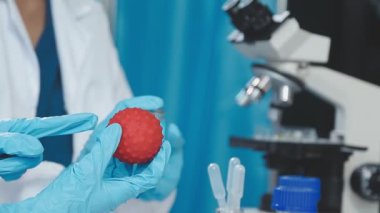Laboratuvar önlüklü bilim adamı laboratuarda sıvı tüpü tutuyor..