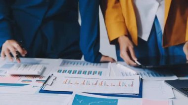 İşadamları mali grafikleri tartışıyor, ofiste belgeler ve belgelerle çalışıyorlar