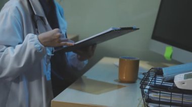 Doktor elinde bir hastanın röntgenini tutuyor ve hastane odasında akıllı bir telefonla konuşuyor. Sağlık ve Tıp Konsepti