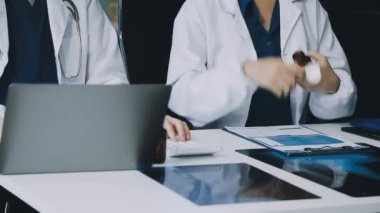 Doktor ve hasta hastane ve sağlık hizmetlerinde masada otururken bir şeyler tartışıyorlar.