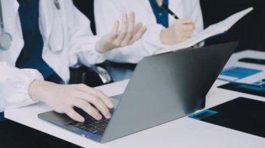 Doktor ofiste dizüstü bilgisayar kullanıyor.