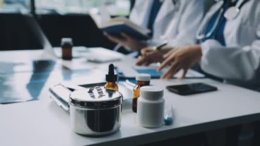 Arka plandaki masada steteskop ve tablet bilgisayarla tıp doktorlarının ellerini kapatın.