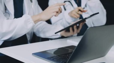 Beyaz önlüklü genç doktor dijital tablet üzerinde çalışıyor.