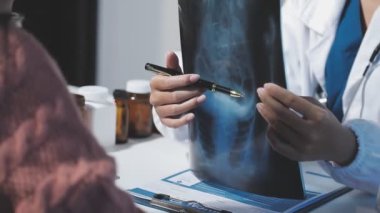 Kadın doktor elinde tablet tutuyor ve hastaya röntgen çekiyor..