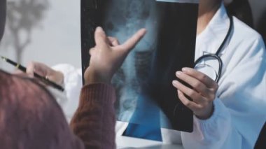 Doktor ve hasta klinikte ve hastanede röntgenleri tartışıyorlar..