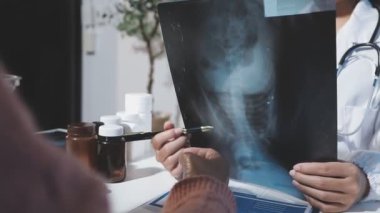Doktor hastaya röntgen görüntüsü gösteriyor