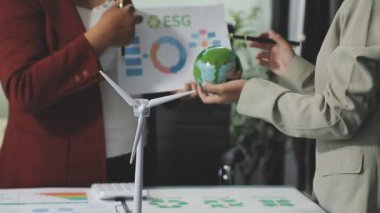 Takım elbiseli iş kadını yeşil ve mavi enerjiyle çalışıyor