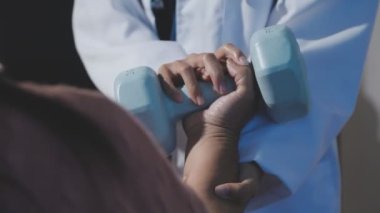 Steteskop tutan doktor, klinikte el ele tutuşan hasta.