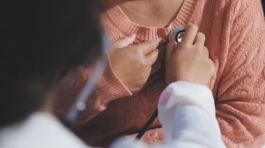 Klinikte genç bir kadını muayene eden bir doktor.