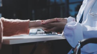 Modern bir muayenehanede bir hastanın muayenesi sırasında bir doktorun eli ve hemşirenin el sıkışması. Tıp ve sağlık hizmetleri kavramı