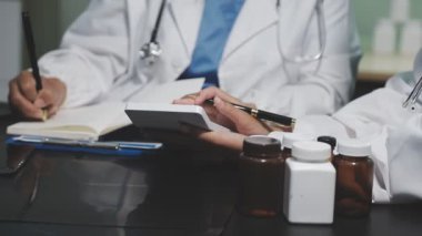 Beyaz önlüklü doktor elinde pano tutuyor.