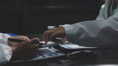 Doktor hastanın elini kontrol ediyor.