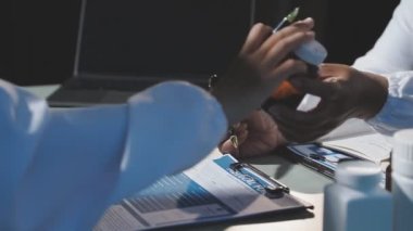 Takım elbiseli genç adam elinde bir kalem tutuyor ve eline bir rapor yazıyor.