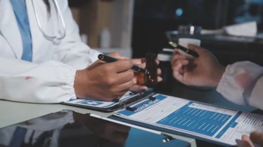 Bir tıp doktorunun elleri elinde haplarla bir pano tutarken..