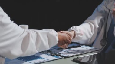 Masadaki genç bir doktorun el sıkışması.