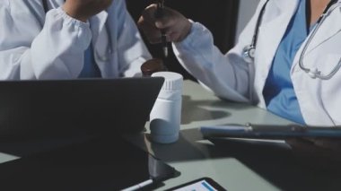 Tıbbi tabletli bir doktor ve ofiste dizüstü bilgisayarı var.